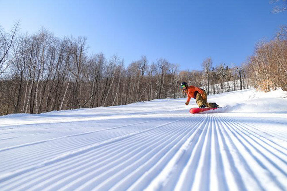 Snowboarder Rides on Fresh Corduroy at Attitash