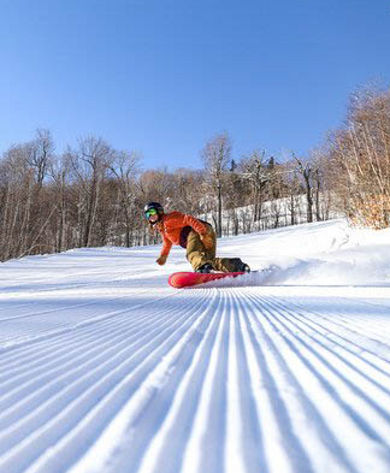 Snowboarder Rides on Fresh Corduroy at Attitash
