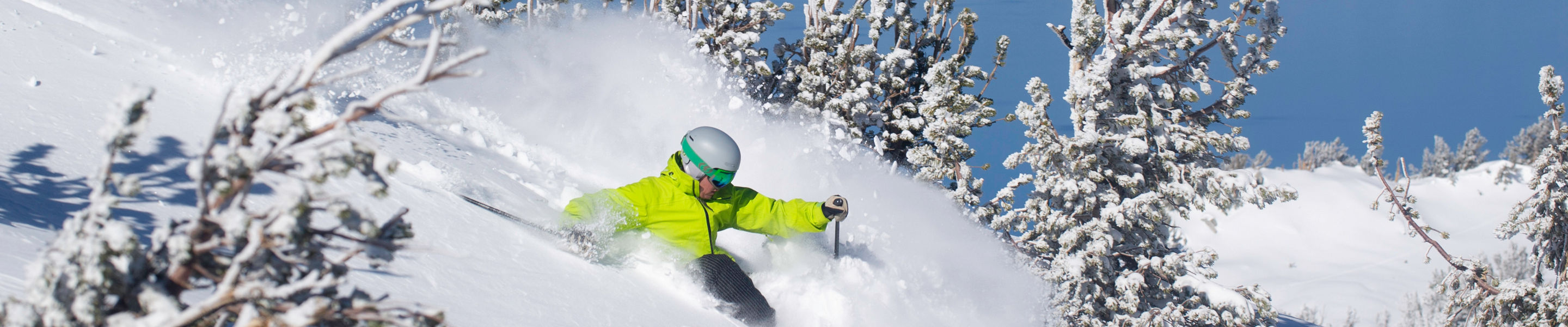 Skier in fresh powder overlooking Lake Tahoe in Heavenly, CA.