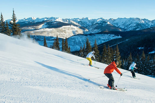 Group Skiing and Snowboarding Groomed Terrain in Vail, CO