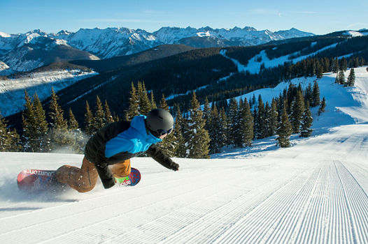 Group Skiing and Snowboarding Groomed Terrain in Vail, CO