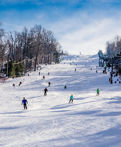 Skiers and Riders Make Turns Downhill at Roundtop