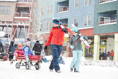 Family walks through village to ski in Keystone, CO.