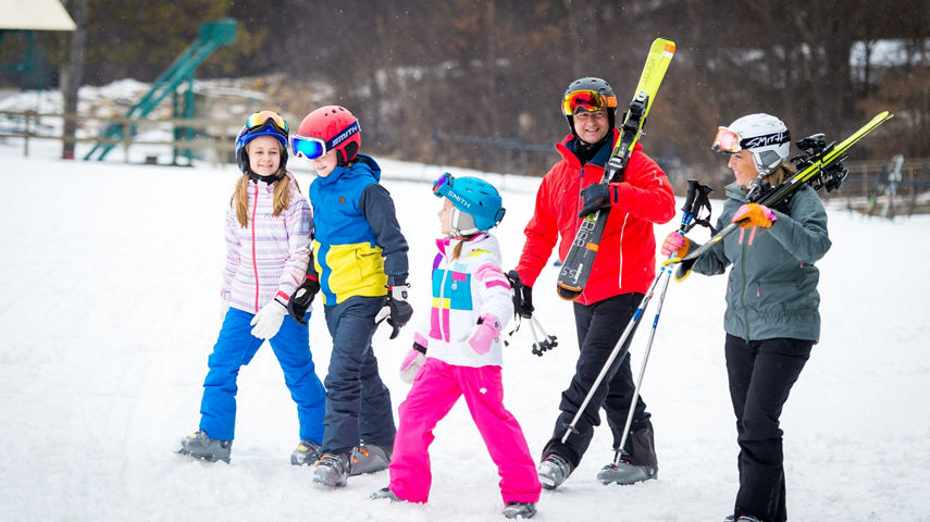 Skier Family Walking With Skis At The Base Of The Alps In Afton Alps, MN