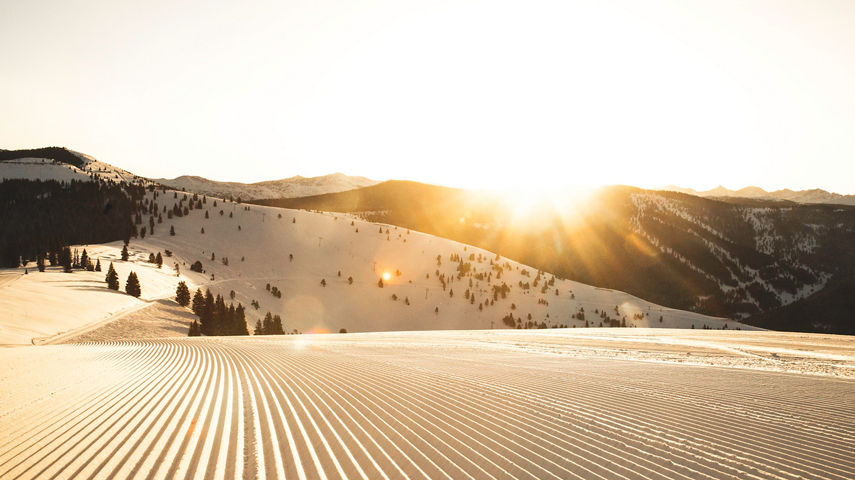 Freshly groomed trail at sunrise in Vail, CO.