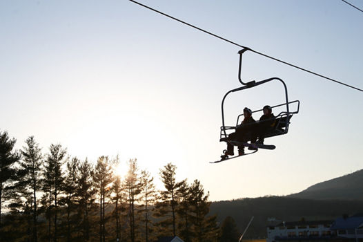 Silhouette of Two Snowboarders Riding the Chairlift at Sunset at Liberty Mountain