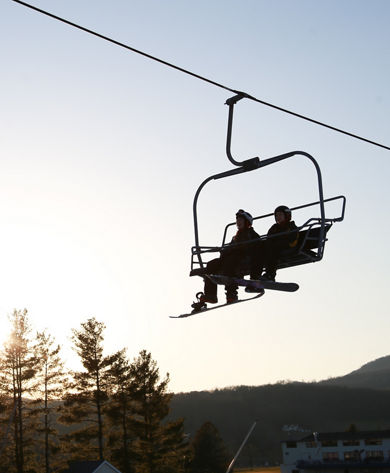 Silhouette of Two Snowboarders Riding the Chairlift at Sunset at Liberty Mountain