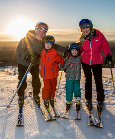 Family skiing together during sunrise at Wilmot Mountain