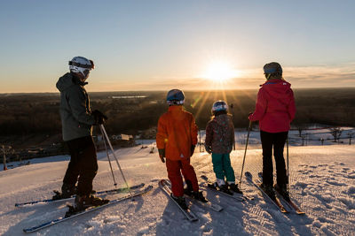 Family skiing together during sunrise at Wilmot Mountain
