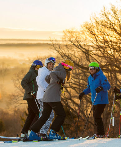 Family skis at sunrise in Wilmot Mountain