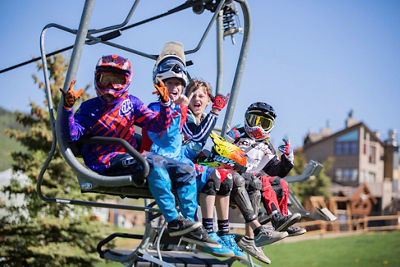 Kids in bike gear take chairlift in Crested Butte, CO.