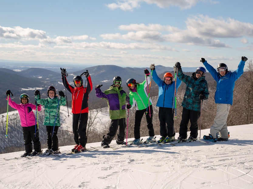Group of Skiers and Riders Pose at Top of Mountain at Whitetail