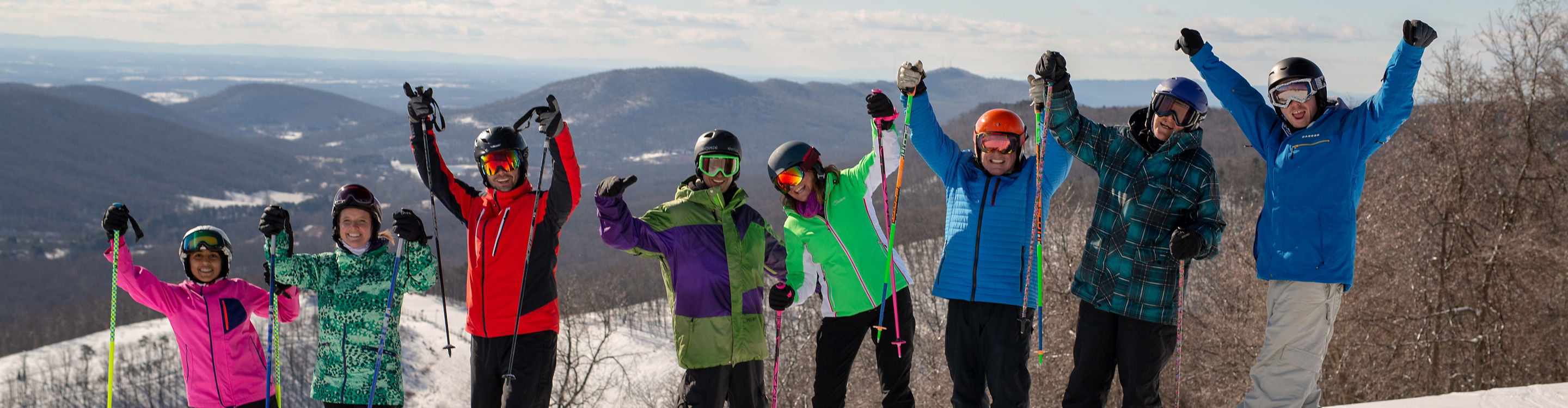 Group of Skiers and Riders Pose at Top of Mountain at Whitetail