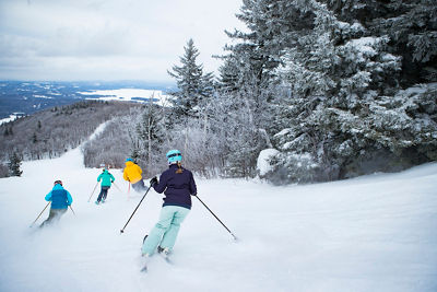 Family skiing on a cloudy day at Mount Sunapee