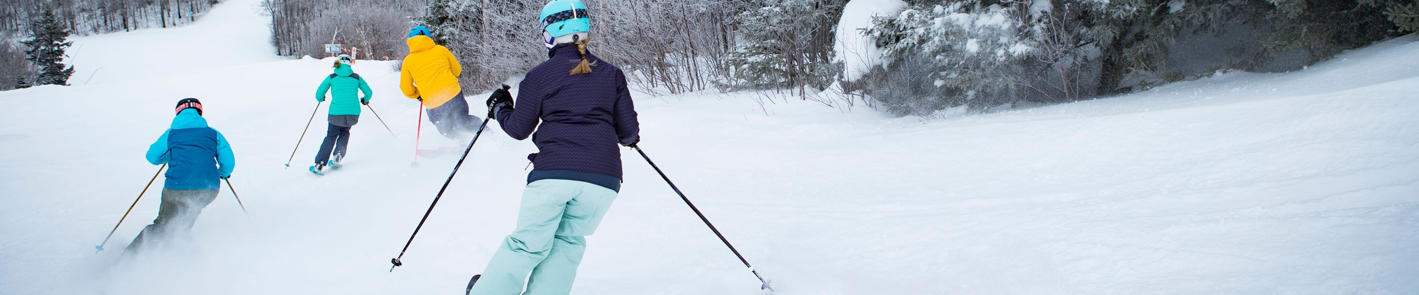 Family skiing on a cloudy day at Mount Sunapee