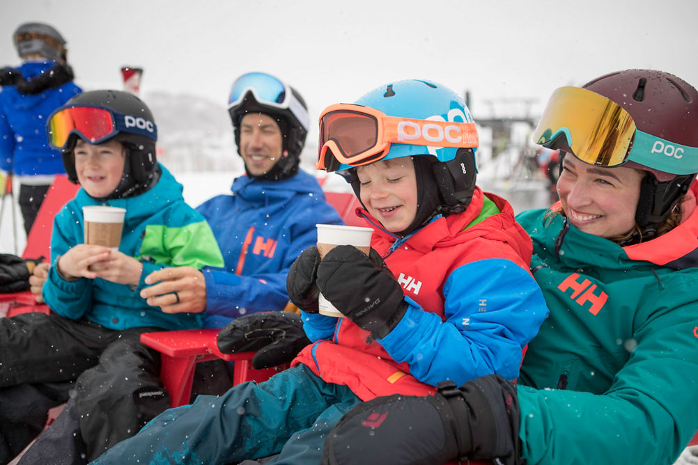 Family enjoys hot cocoa at the base of the mountain in Park City, UT.