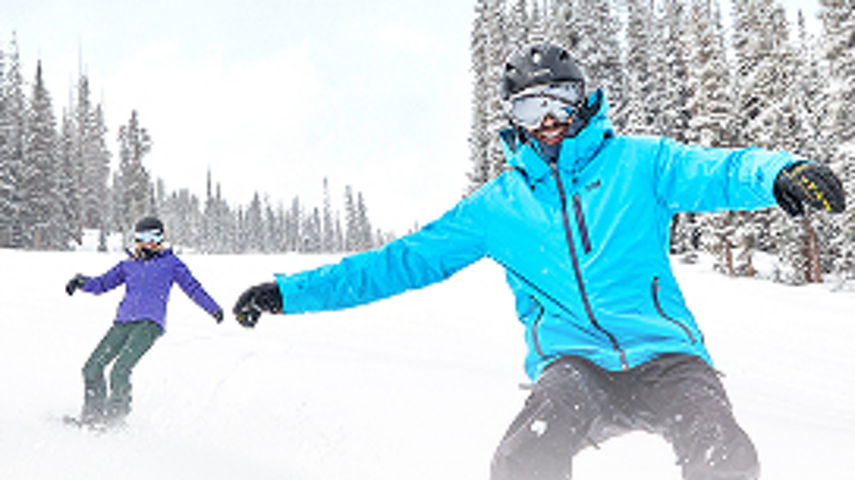 Friends snowboard on fresh fallen snow in Keystone, CO - CROPPED
