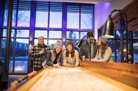 Friends play games at a bar in town in Stowe, VT.