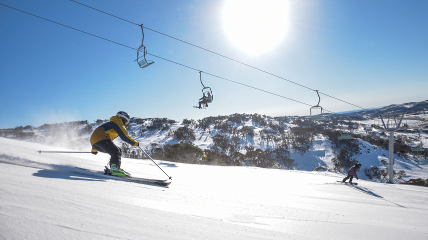 A skier enjoying a sunny turn on Towers run down MT Perisher