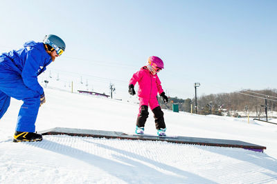 Kid's snowboard school in the terrain park at Mt. Brighton, MI.