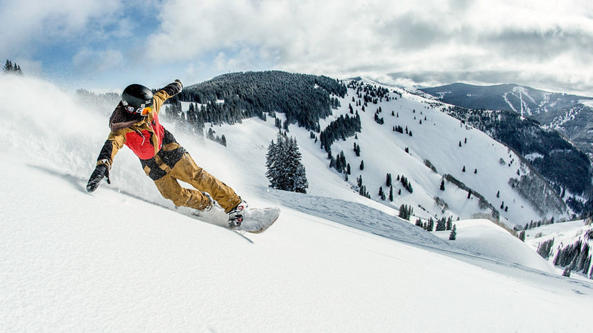 Snowboarder in powder in the Back Bowls at Vail, CO