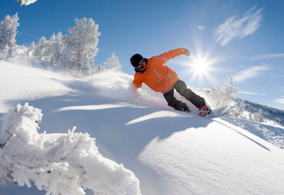 Snowboarder turns in fresh powder in Vail, CO.