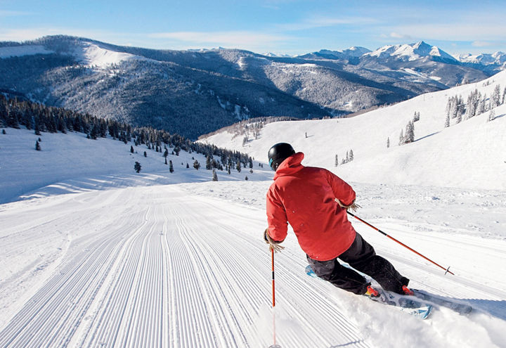 Skier carves freshly groomed snow in the Back Bowls at Vail, CO