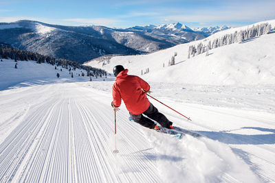 Skier carves freshly groomed snow in the Back Bowls at Vail, CO.