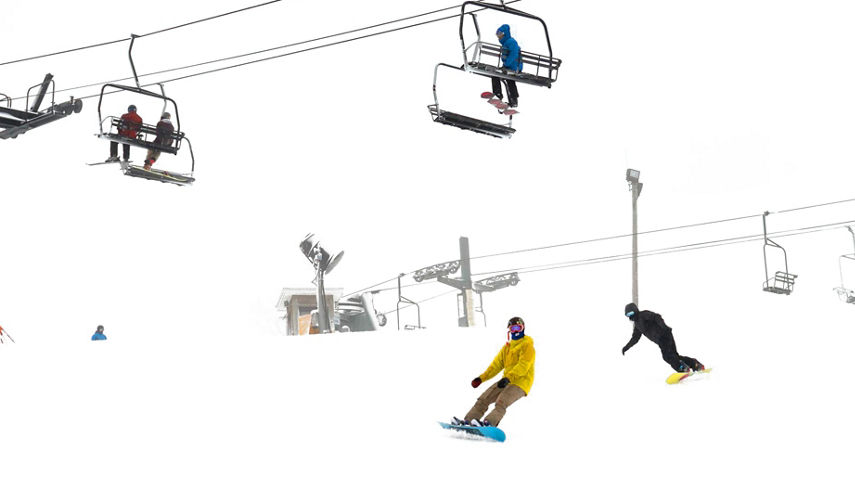 Snowboarder Rides Under Chairlift on Snowy Day at Mad River Mountain