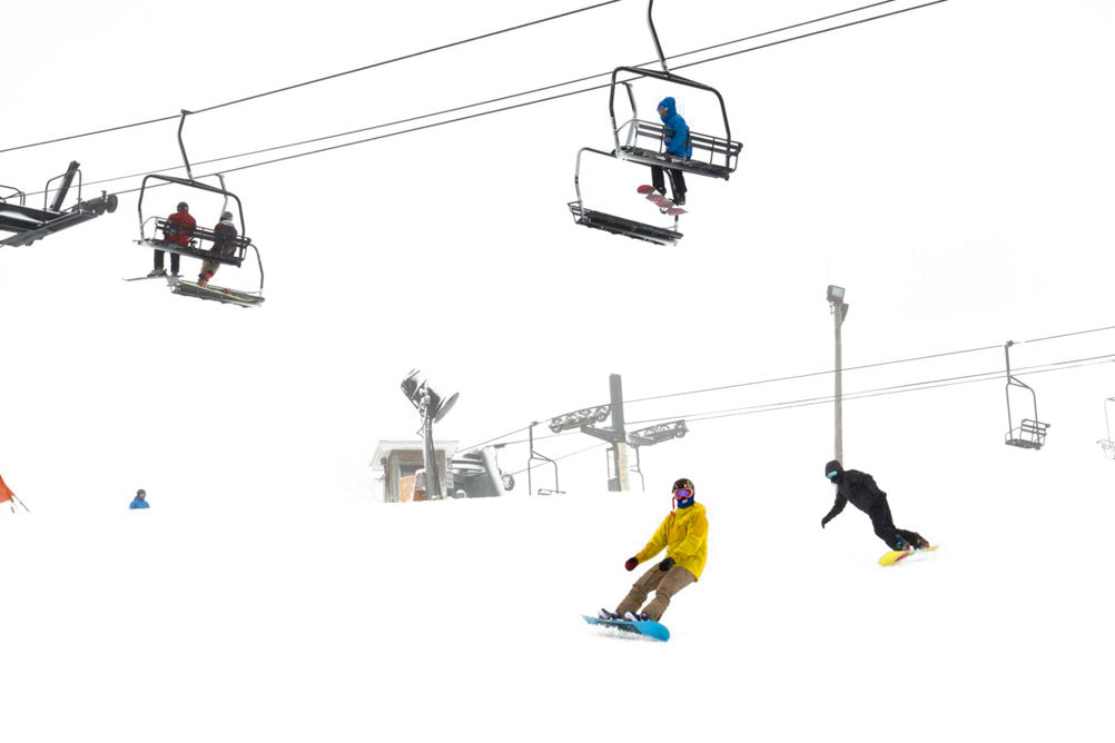 Snowboarder Rides Under Chairlift on Snowy Day at Mad River Mountain