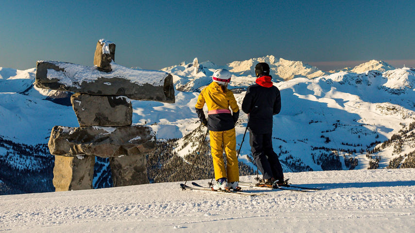 Skiers admiring the Inukshuk in Whistler Blackcomb.