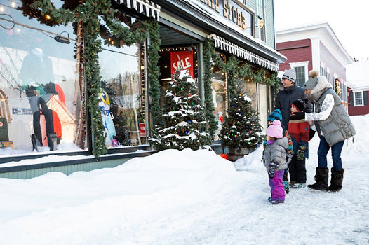 Family walks through the storefronts in the village at Stowe, VT.