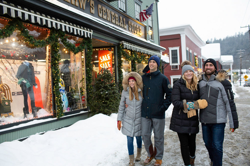Couples walk around the village exploring storefronts in Stowe, VT.
