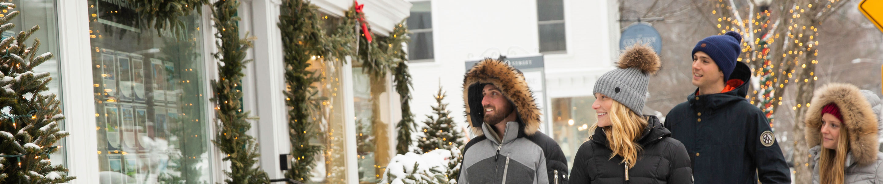Couples walk around the village exploring storefronts in Stowe, VT.