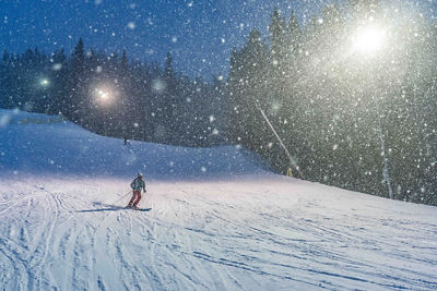 Snow falling during night skiing on Dercum in Keystone, CO.