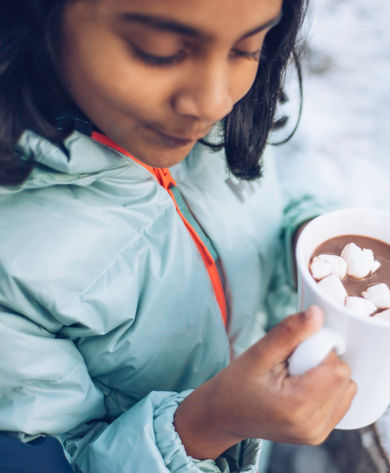Family enjoying smores and hot cocoa in the snow in Northstar, CA.