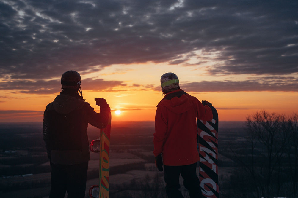 Snowboarders Watch the Sunset at the Top of Liberty Mountain