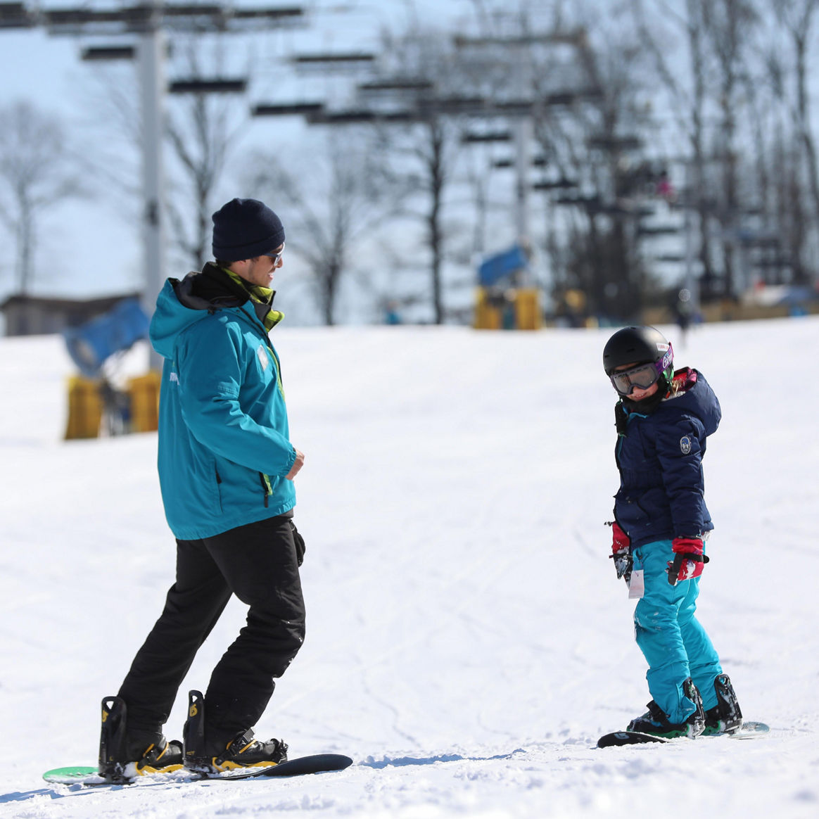 Snowboarding Instructor Teaches Child How to Ride at Liberty Mountain