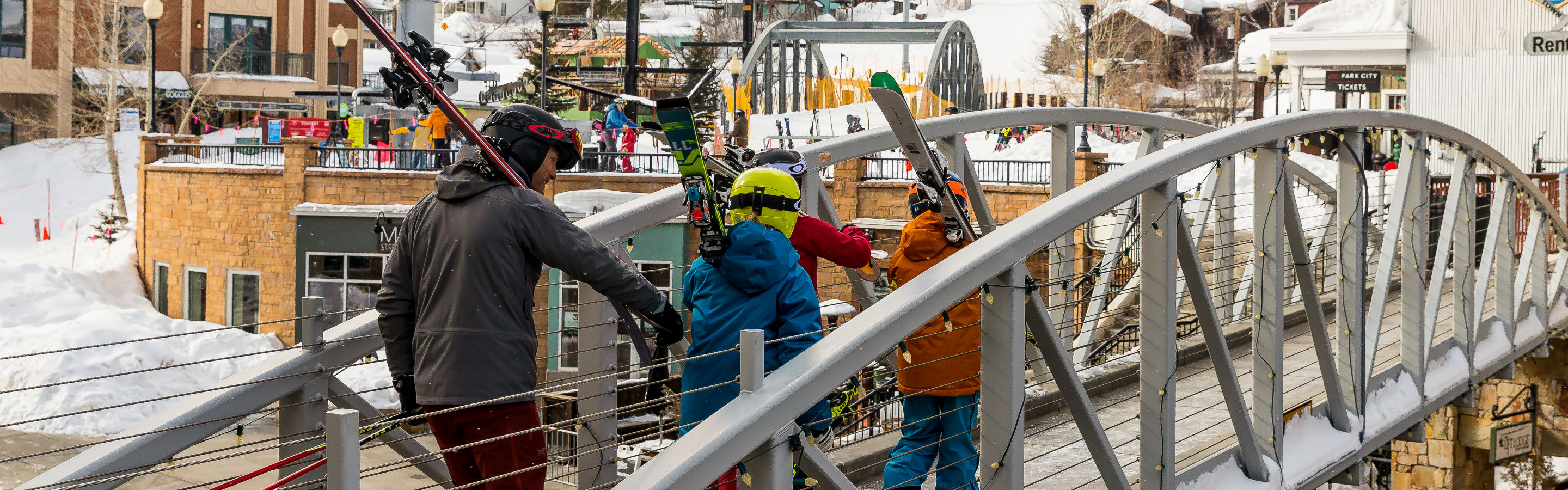 Family walking on town bridge to go skiing at Park City