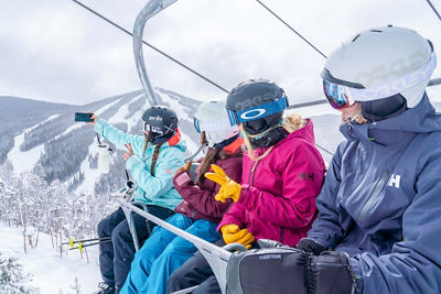 Friends ride the Ruby chairlift back from the bottom of North Peak on a snowy day in Keystone, CO.
