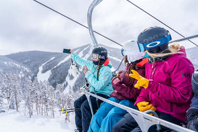 Friends ride the Ruby chairlift back from the bottom of North Peak on a snowy day in Keystone, CO.