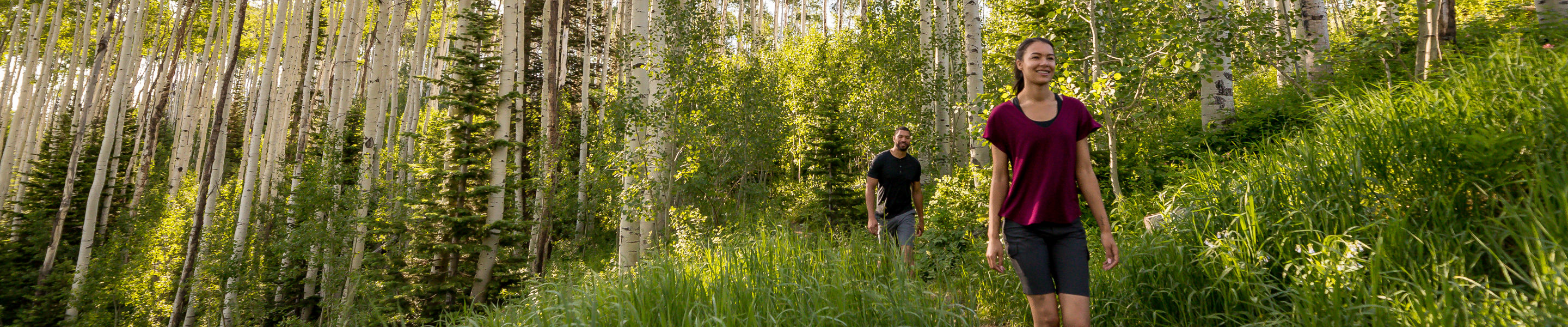 A couple walks on a trail during a summer day at Park City