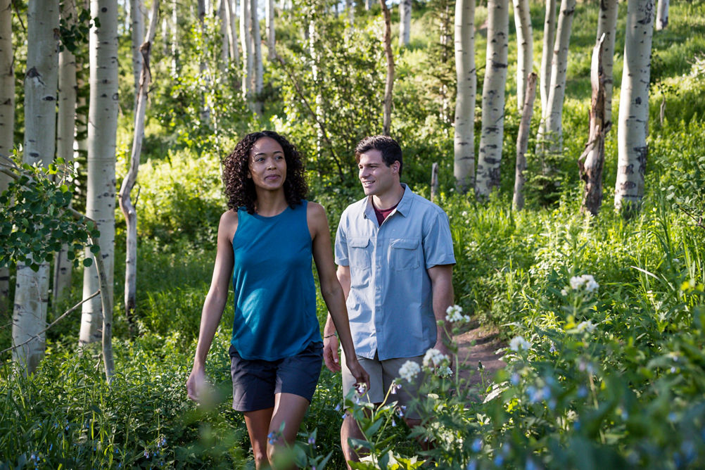 A couple walks along a nature path during summer at Park City