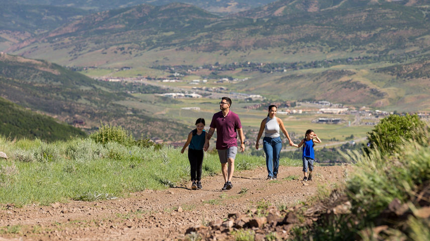 Parents and their children walk along a path one summer day at Park City