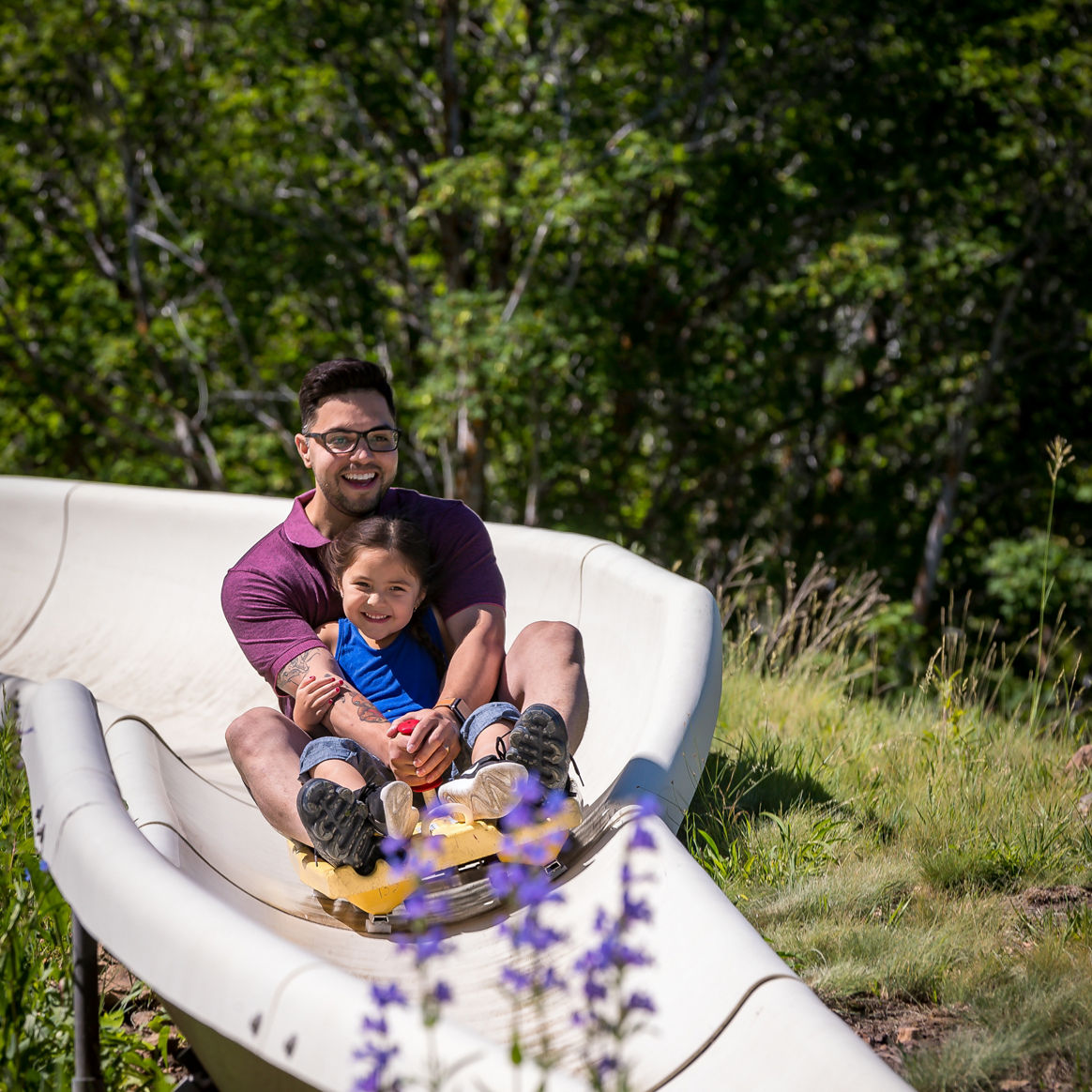 Dad and daughter duo enjoy the Alpine Coaster on a summer day at Park City