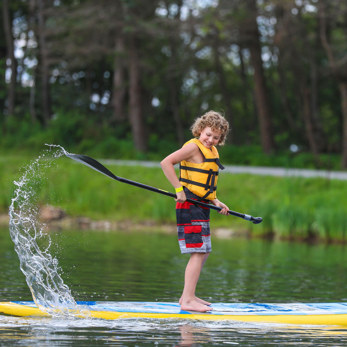 Child Enjoys Stand Up Paddleboarding at Seven Springs