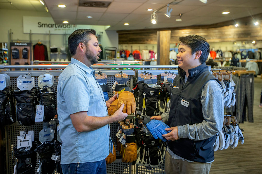 Man shopping for gloves at Epic Mountain Gear
