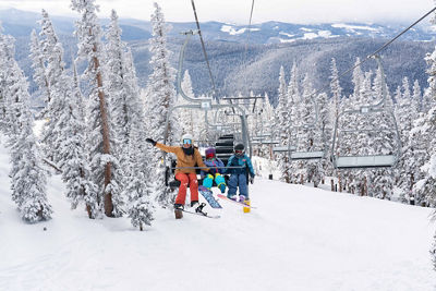 Mother and two young daughters snowboard in Keystone, CO.