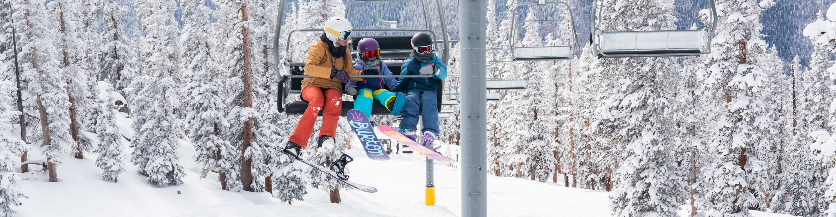 Mother and two young daughters snowboard in Keystone, CO.