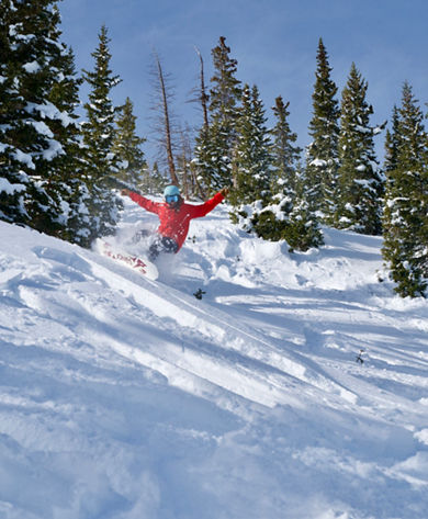 Snowboarder slashing powder in Horseshoe bowl at Breckenridge